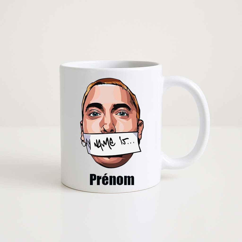 Mug blanc 330ml avec Eminem dans sa pose "My Name Is", bandeau sur la bouche, espace pour un prénom personnalisable.