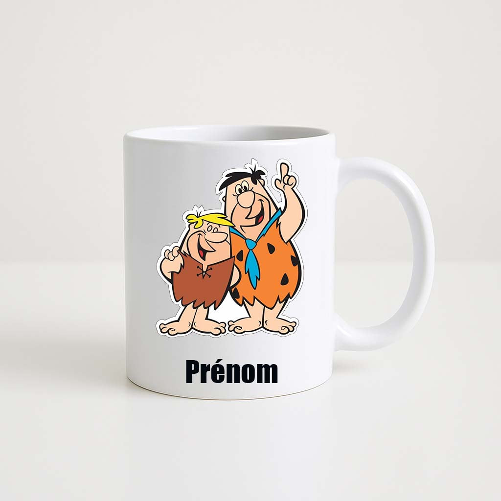 Mug blanc 330ml avec Fred et Barney, duo préhistorique avec clubs, espace pour un prénom personnalisable.