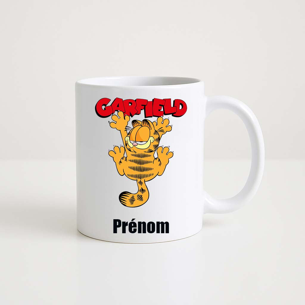 Mug blanc 330ml avec Garfield, chat orange mangeant des lasagnes, espace pour un prénom personnalisable.