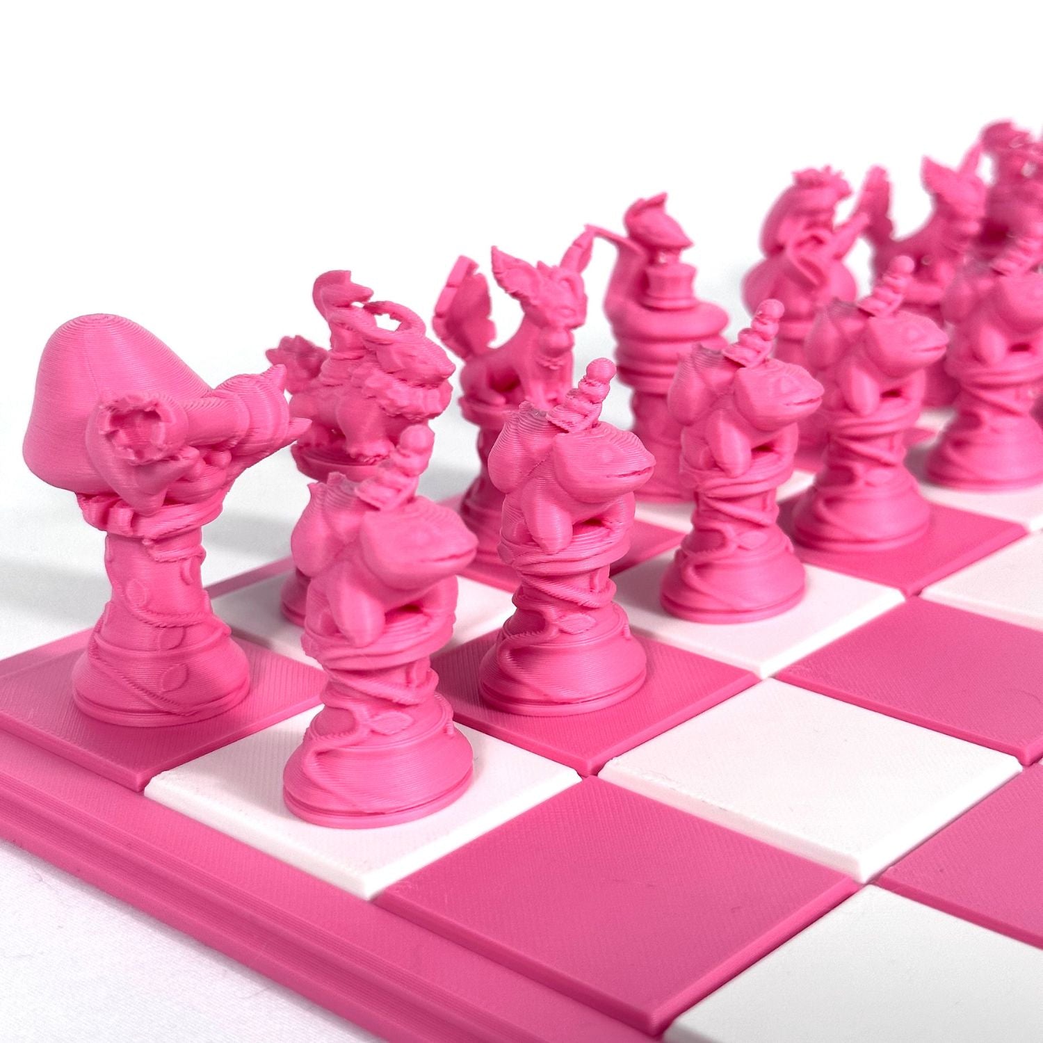 Set de pièces d’échecs Pokémon rose imprimées en 3D – vue rapprochée sur échiquier blanc et rose
