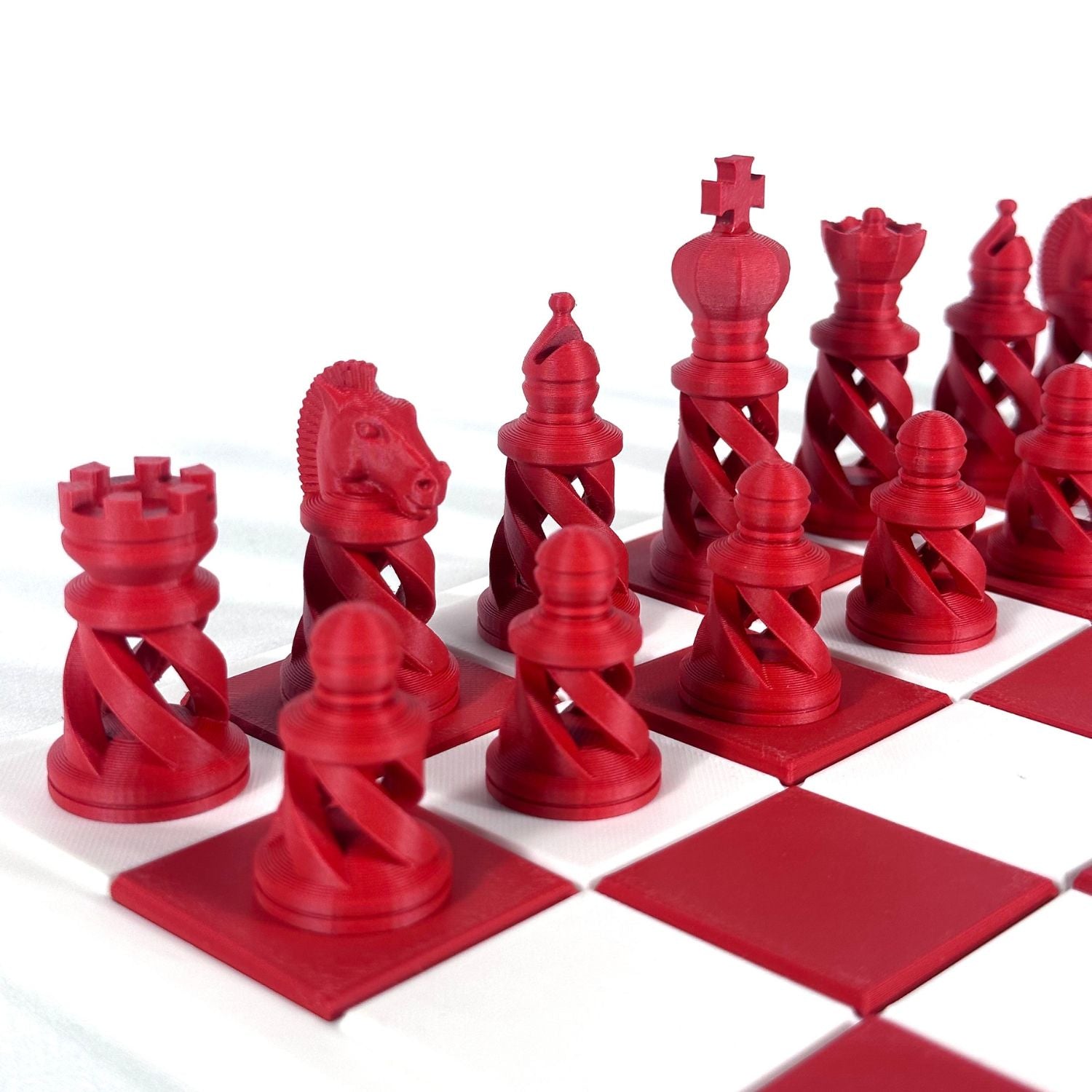 Pièces d’échecs modernes rouges imprimées en 3D sur plateau blanc et rouge – style design et contemporain.