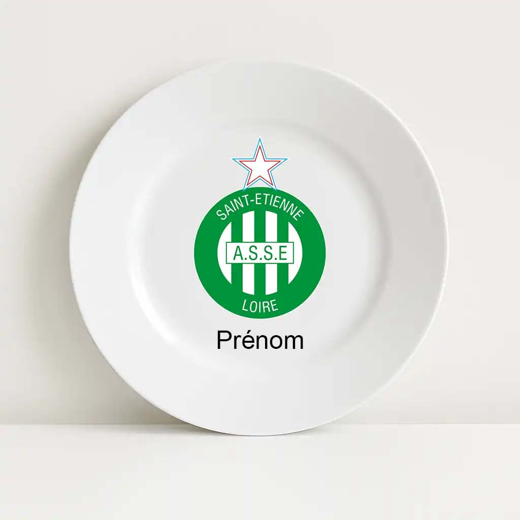 Assiette blanche incassable décorée du logo emblématique du club AS Saint-Étienne, en vert et blanc, avec une étoile rouge au sommet. Le mot “Prénom” est inscrit en dessous, laissant place à une personnalisation au nom de l’enfant ou du supporter.