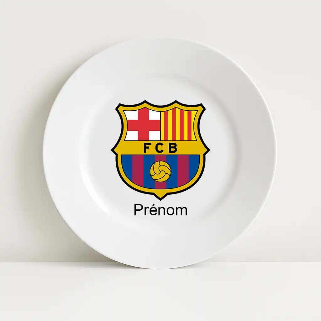Assiette blanche incassable personnalisée avec le logo officiel du FC Barcelone, comprenant les couleurs rouge, jaune, bleu et une croix rouge. Le mot “Prénom” est inscrit en dessous pour la personnalisation du produit.