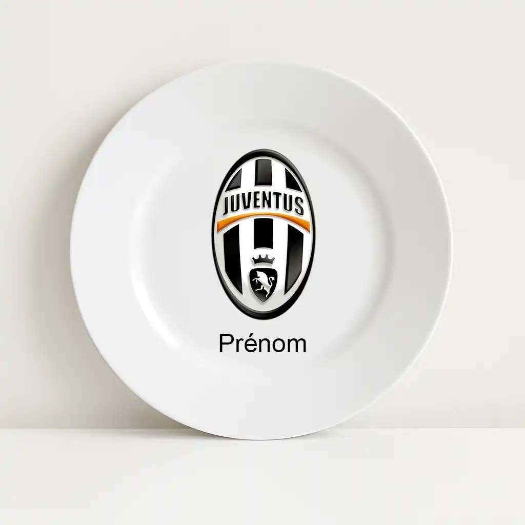 Assiette blanche incassable avec le logo classique du club Juventus en noir et blanc, agrémenté d’un liseré orange. Le mot “Prénom” est inscrit en dessous du logo, suggérant une personnalisation possible.