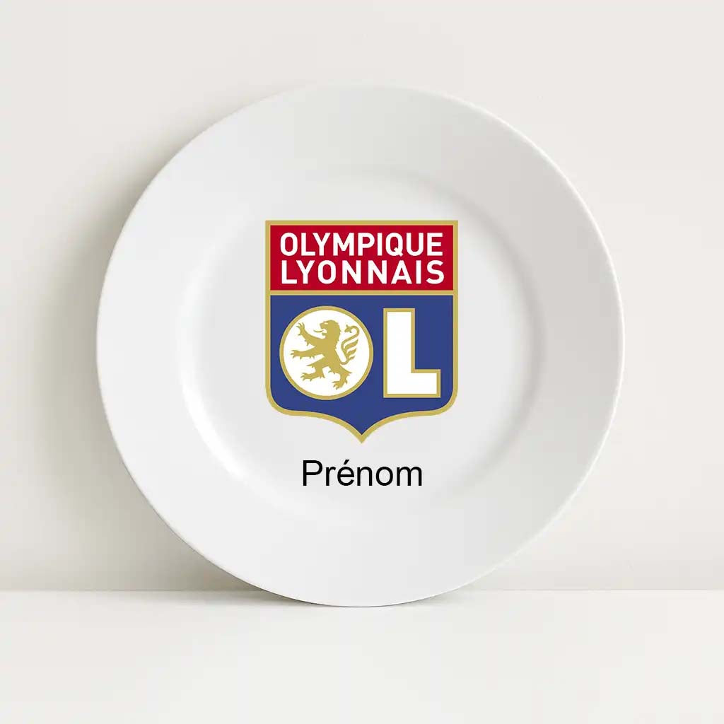 Assiette blanche incassable décorée du logo de l’Olympique Lyonnais. Le blason emblématique du club, avec le lion doré et les couleurs rouge, bleu et blanc, est imprimé au centre. En dessous, le mot "Prénom" est prévu pour personnalisation.

