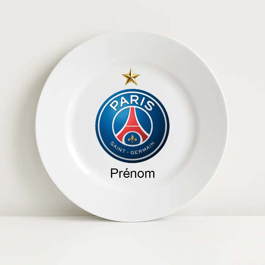 Assiette blanche incassable avec le logo du Paris Saint-Germain (PSG) imprimé en son centre. Le blason rond du club est surmonté d’une étoile dorée. En dessous du logo figure le mot "Prénom" pour une personnalisation avec le nom de l’enfant ou d’un fan.