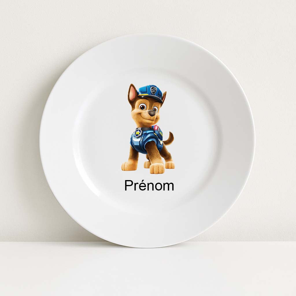 Assiette blanche incassable avec une illustration du personnage Chase de la Pat’Patrouille au centre, accompagnée de l’inscription personnalisable “Prénom” en dessous.