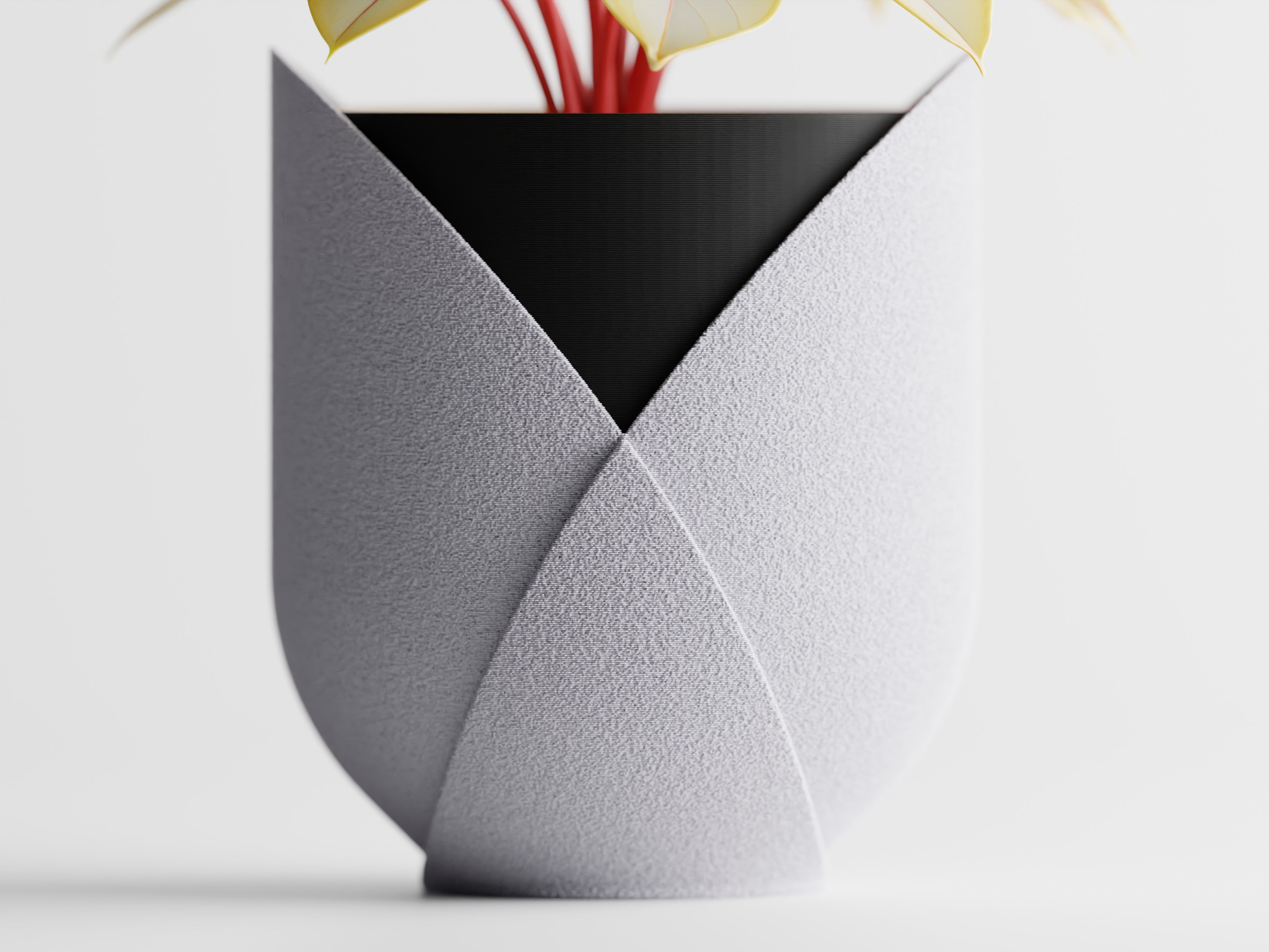 Pot de fleurs moderne Elyndra au design sculptural et épuré, contenant une plante aux tiges rouges.