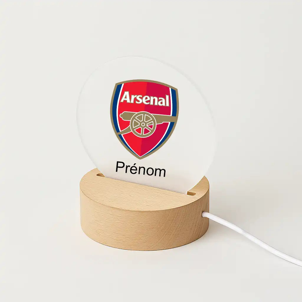 Lampe LED personnalisable avec le logo d' Arsenal, posée sur une base en bois clair, avec l'inscription "Prénom" sous l'écusson du club.