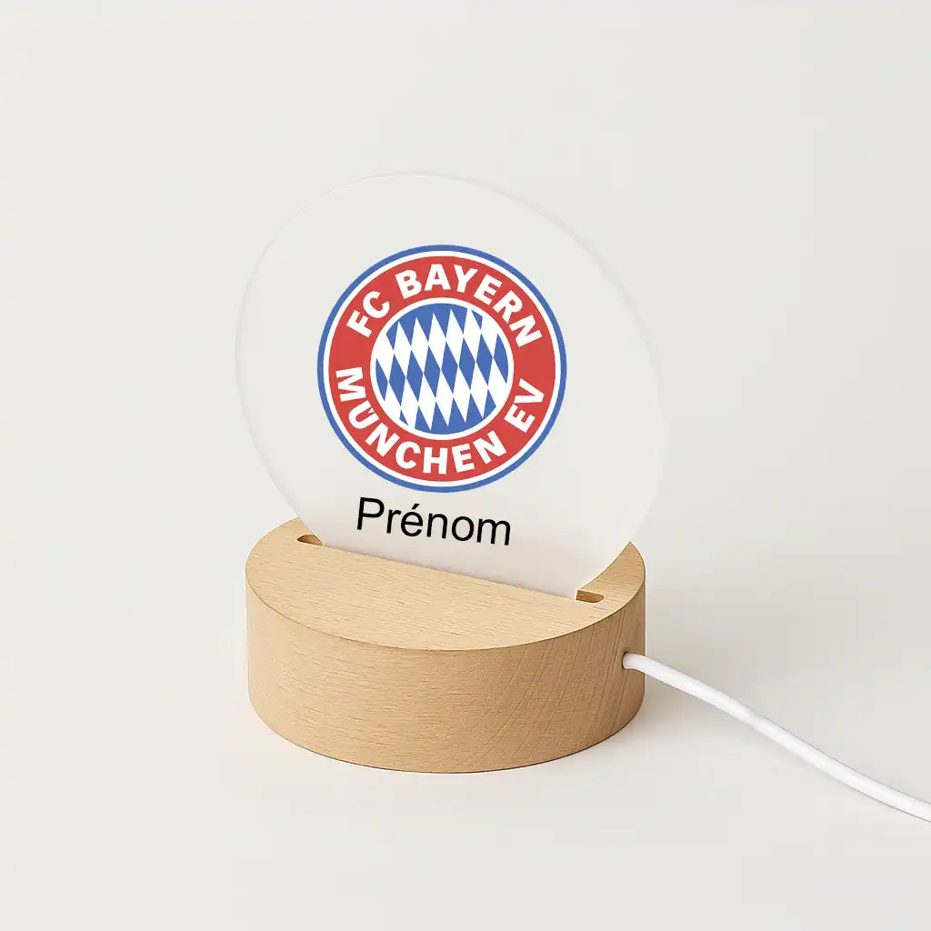 Lampe LED personnalisable avec le logo du Bayern Munich, posée sur une base en bois clair, avec l'inscription "Prénom" sous l'écusson du club.