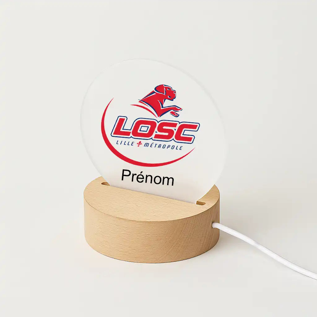 Lampe LED personnalisable avec le logo du Losc, posée sur une base en bois clair, avec l'inscription "Prénom" sous l'écusson du club.