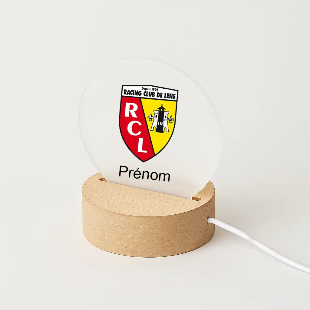 Lampe LED personnalisable avec le logo du RC Lens, posée sur une base en bois clair, avec l'inscription "Prénom" sous l'écusson du club.