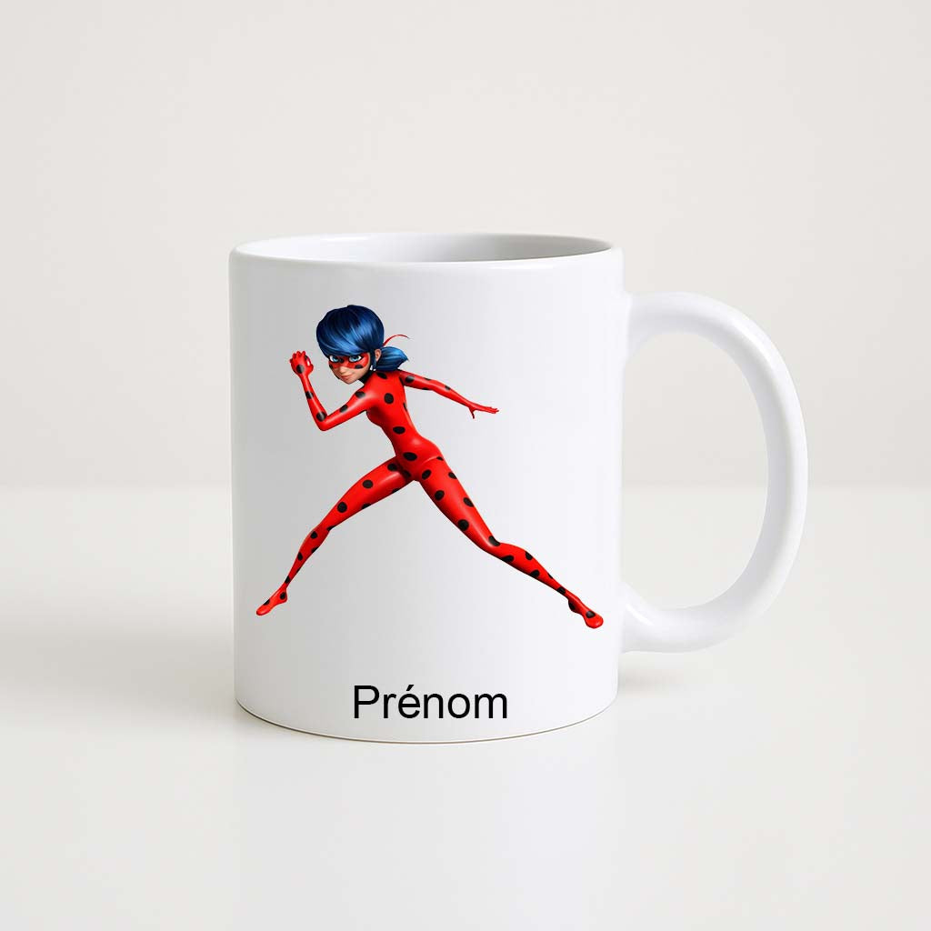 Mug blanc 330 ml Ladybug Miraculous en pleine action avec espace prénom personnalisable.