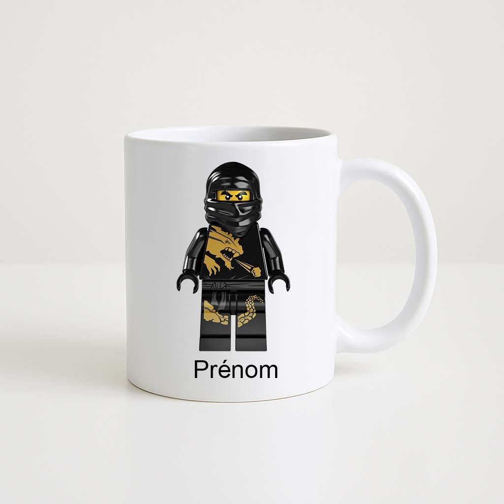 Mug blanc 330 ml avec figurine ninja Lego noir et doré, personnalisable avec un prénom.