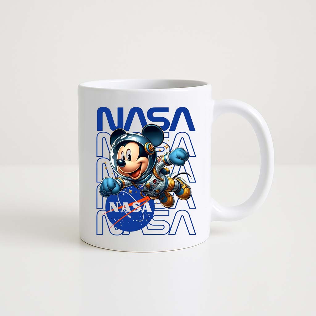 Mug blanc 330 ml avec illustration d’un personnage ressemblant à Mickey Mouse en combinaison d’astronaute devant le logo NASA