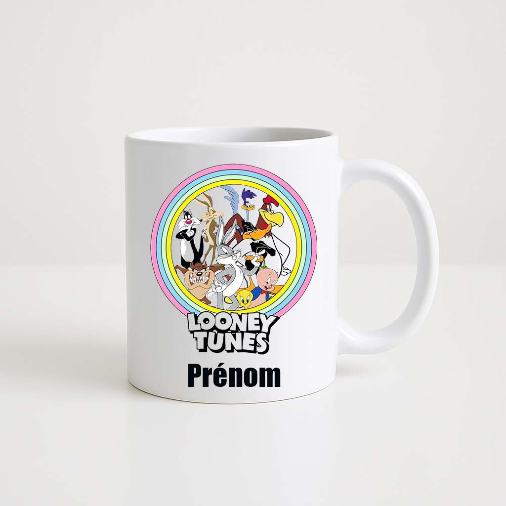 Mug blanc 330ml avec tous les Looney Tunes (Bugs, Daffy, Porky, Tweety, Taz, Road Runner) dans un arc-en-ciel coloré, espace pour un prénom personnalisable.