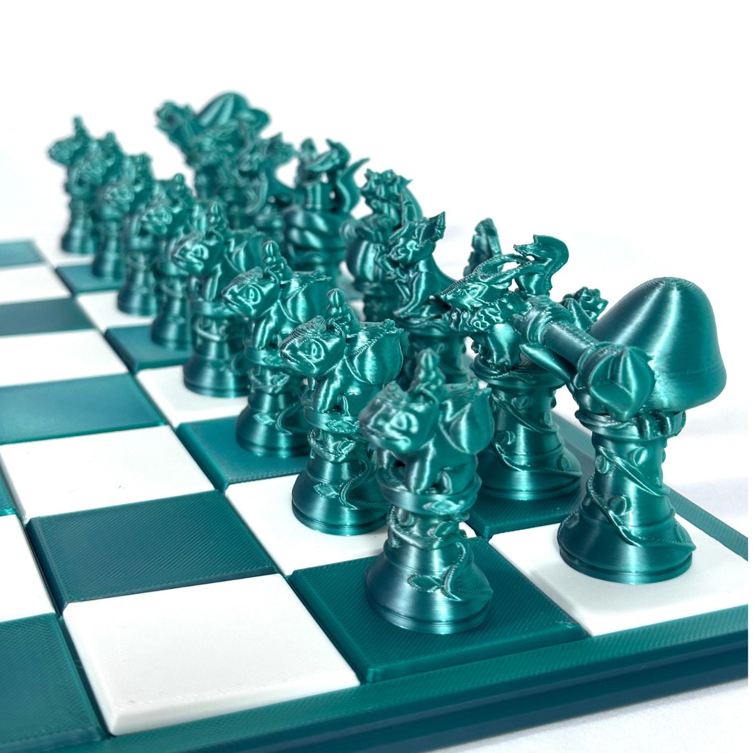 Pièces d’échecs fantasy style Pokémon en impression 3D jade chromé, vues en gros plan sur échiquier.