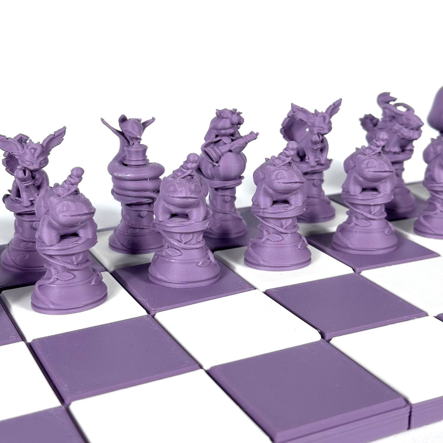 Gros plan sur les pièces d’échecs Pokémon violet pastel au design détaillé et artisanal, sans plateau.