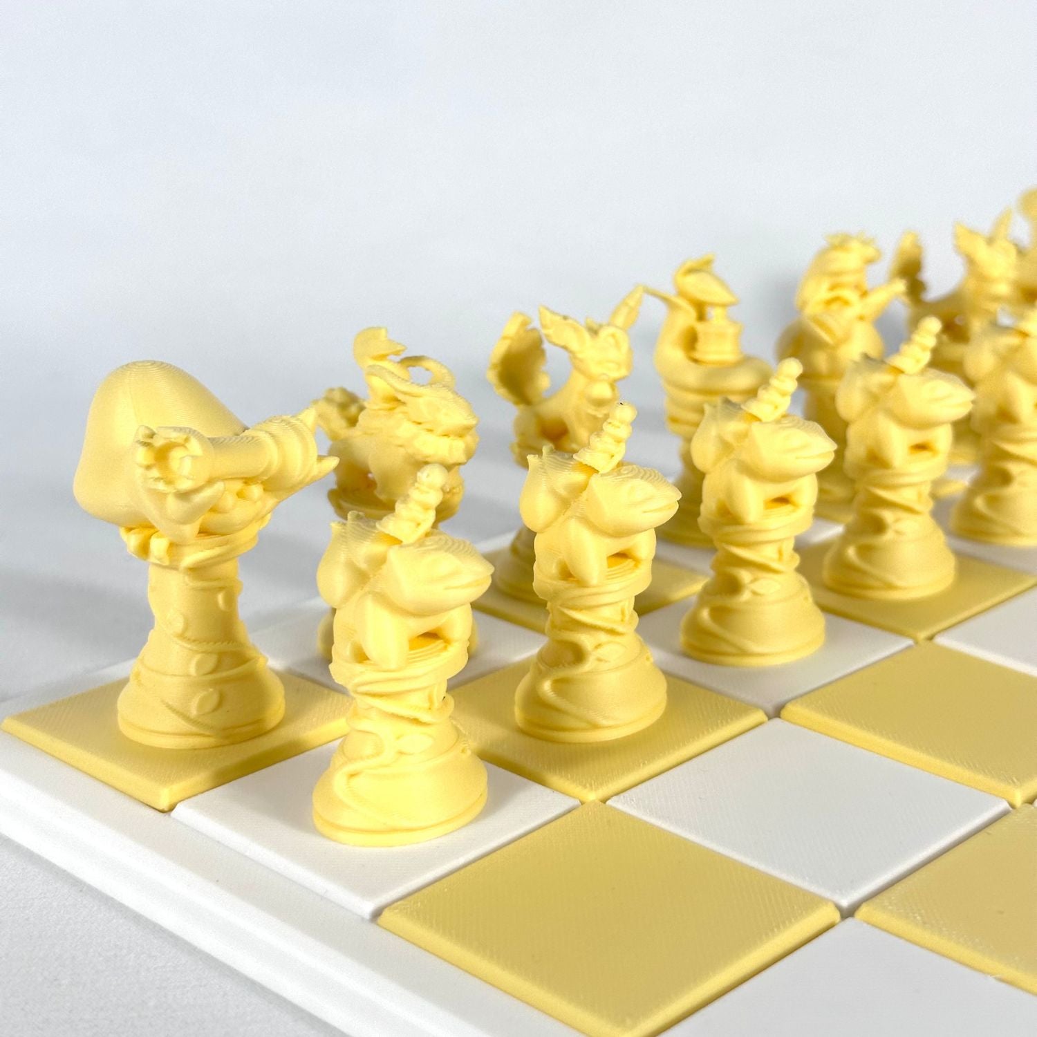 Pièces d’échecs Pokémon jaunes imprimées en 3D alignées sur plateau blanc et jaune – set unique personnalisé.