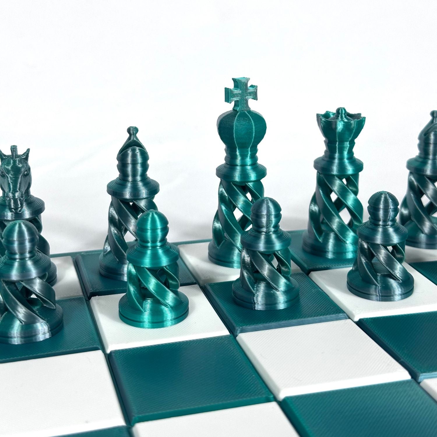 Zoom sur pièces d’échecs contemporaines vert jade et chromées, idéal cadeau stylé pour tous âges et passionnés.