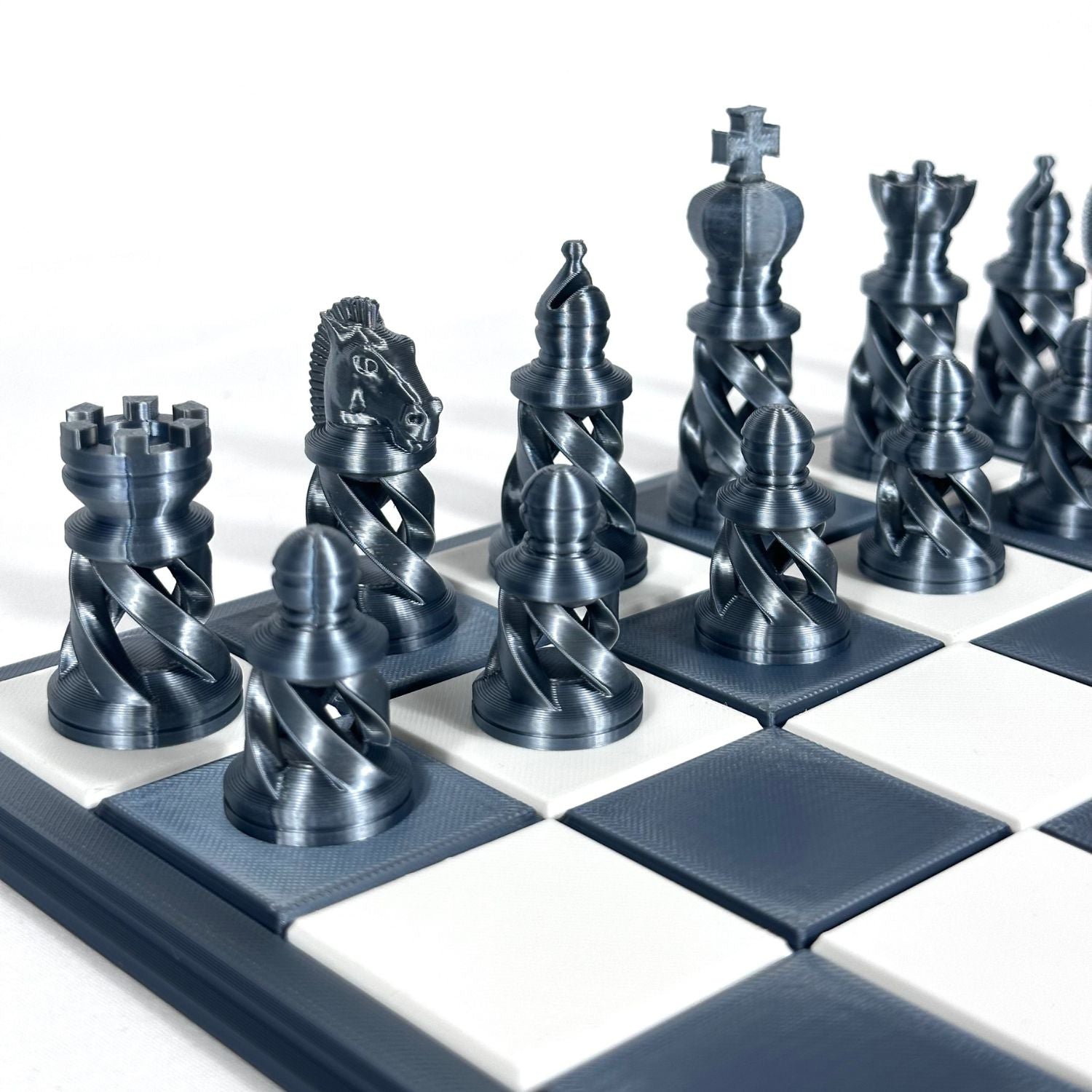 Set de pièces d’échecs modernes couleur chrome métallisé sur plateau noir et blanc, design ajouré et impression 3D professionnelle.