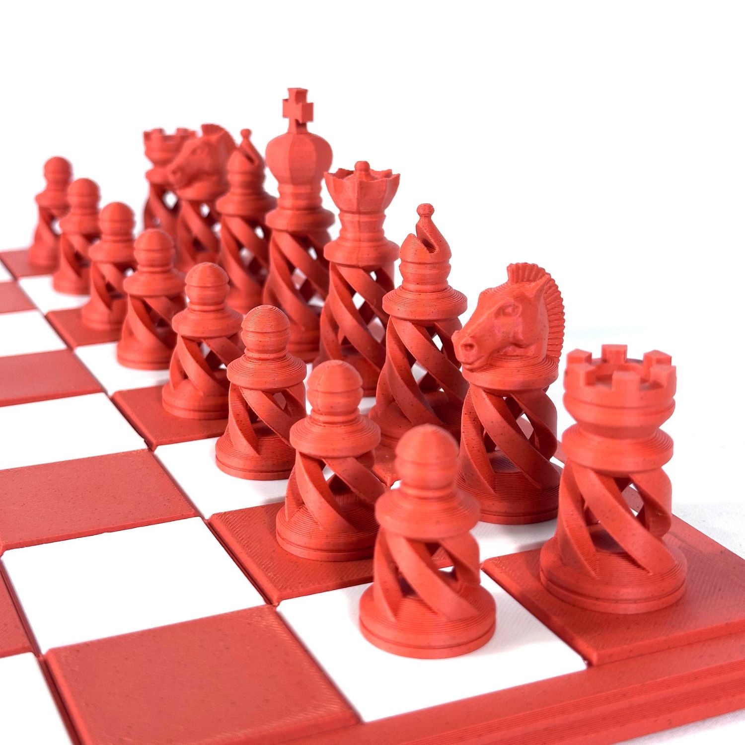 Ensemble complet de pièces d’échecs modernes brique sur échiquier rouge et blanc