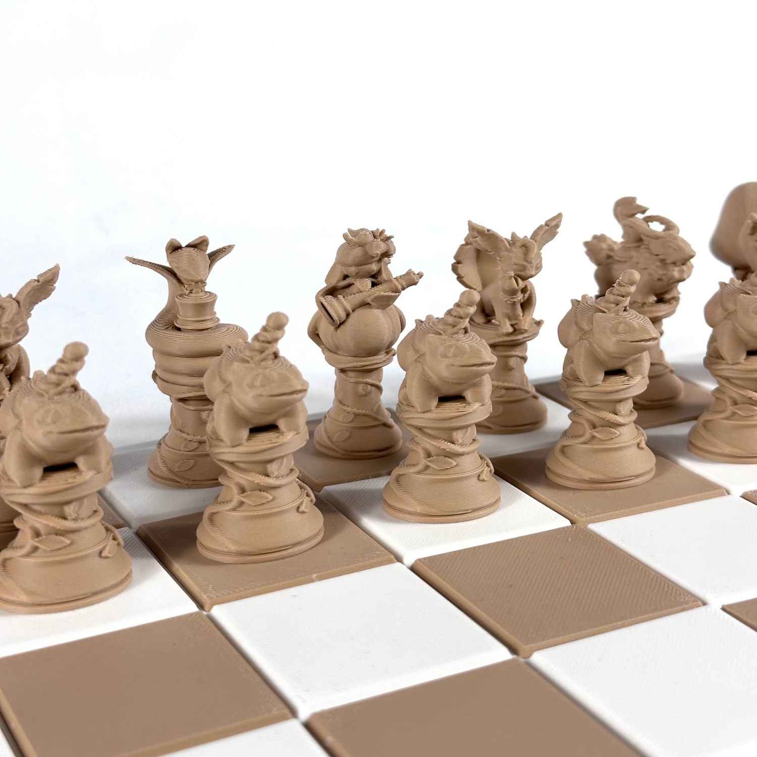 Gros plan sur les pièces d’échecs Pokémon beige imprimées en 3D, au design détaillé et soigné.