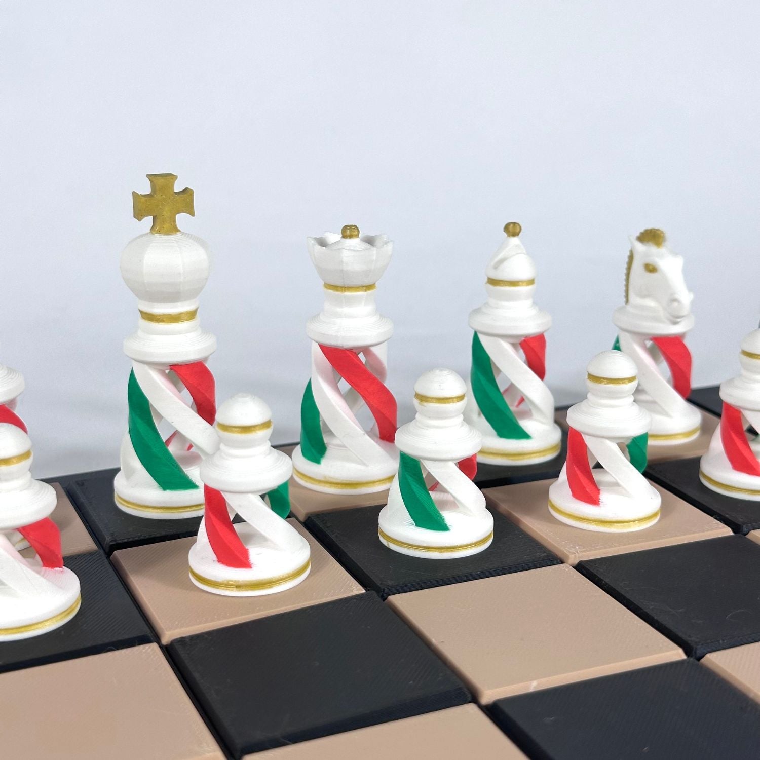 Zoom sur pièces d’échecs inspirées du drapeau italien, fabrication 3D de précision avec détails dorés.
