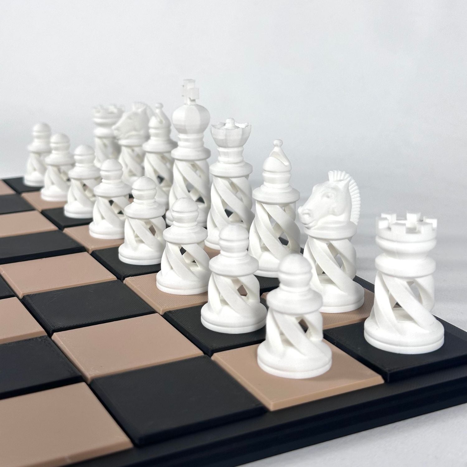 Set d’échecs moderne couleur blanc pur, design spiralé, sur plateau contrasté.