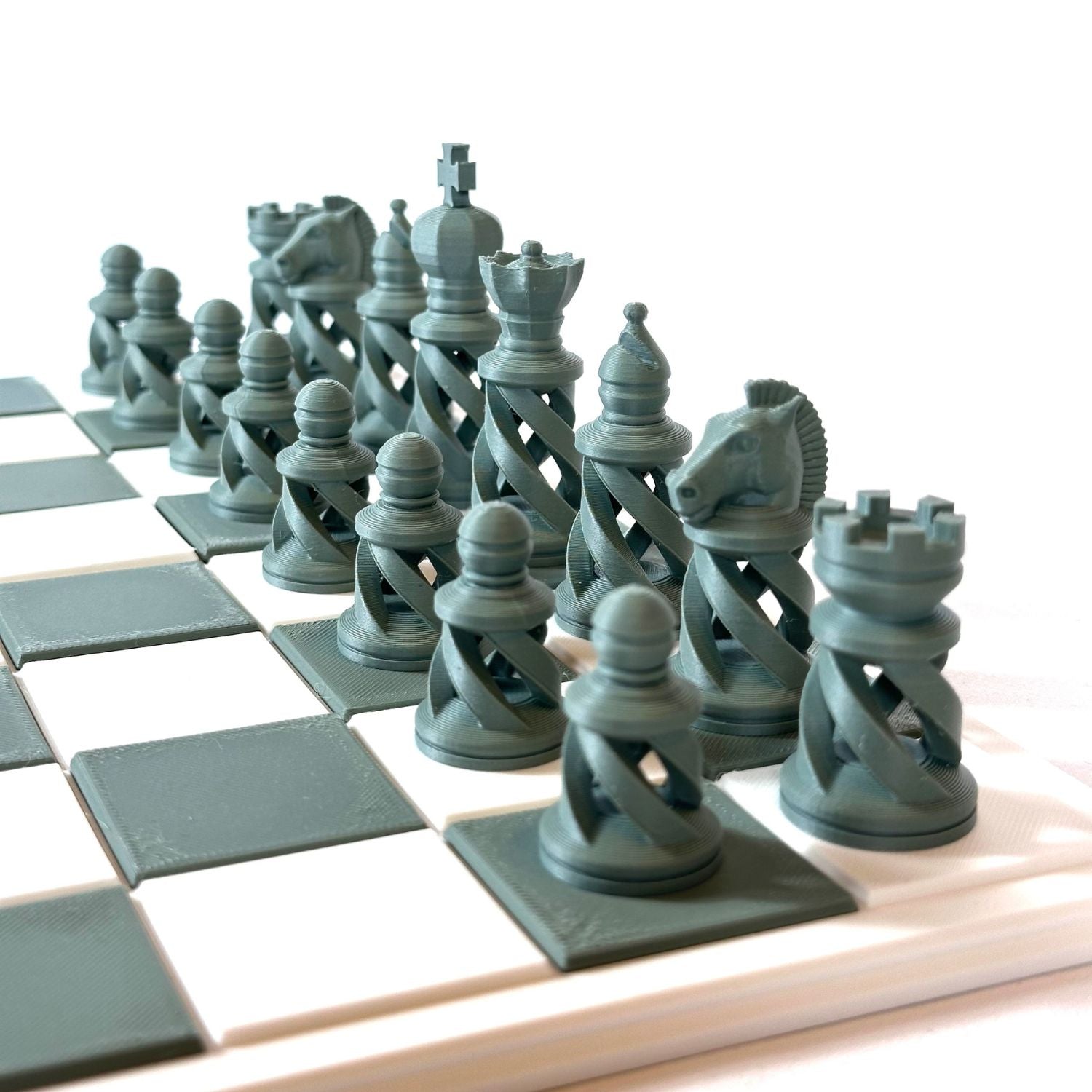 Set d’échecs couleur vert tendance au design spiralé, posé sur un plateau épuré.