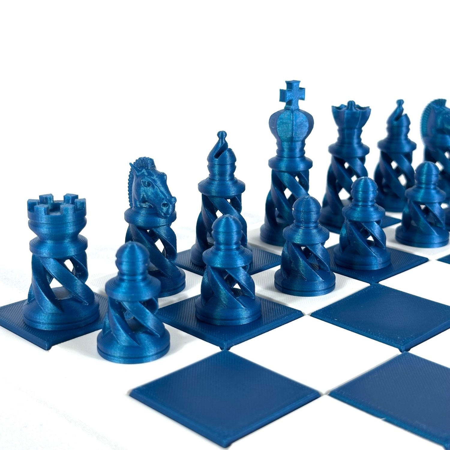 Pièces d’échecs modernes bleu Starlight Neptune sur échiquier blanc et bleu – design spiralé contemporain.