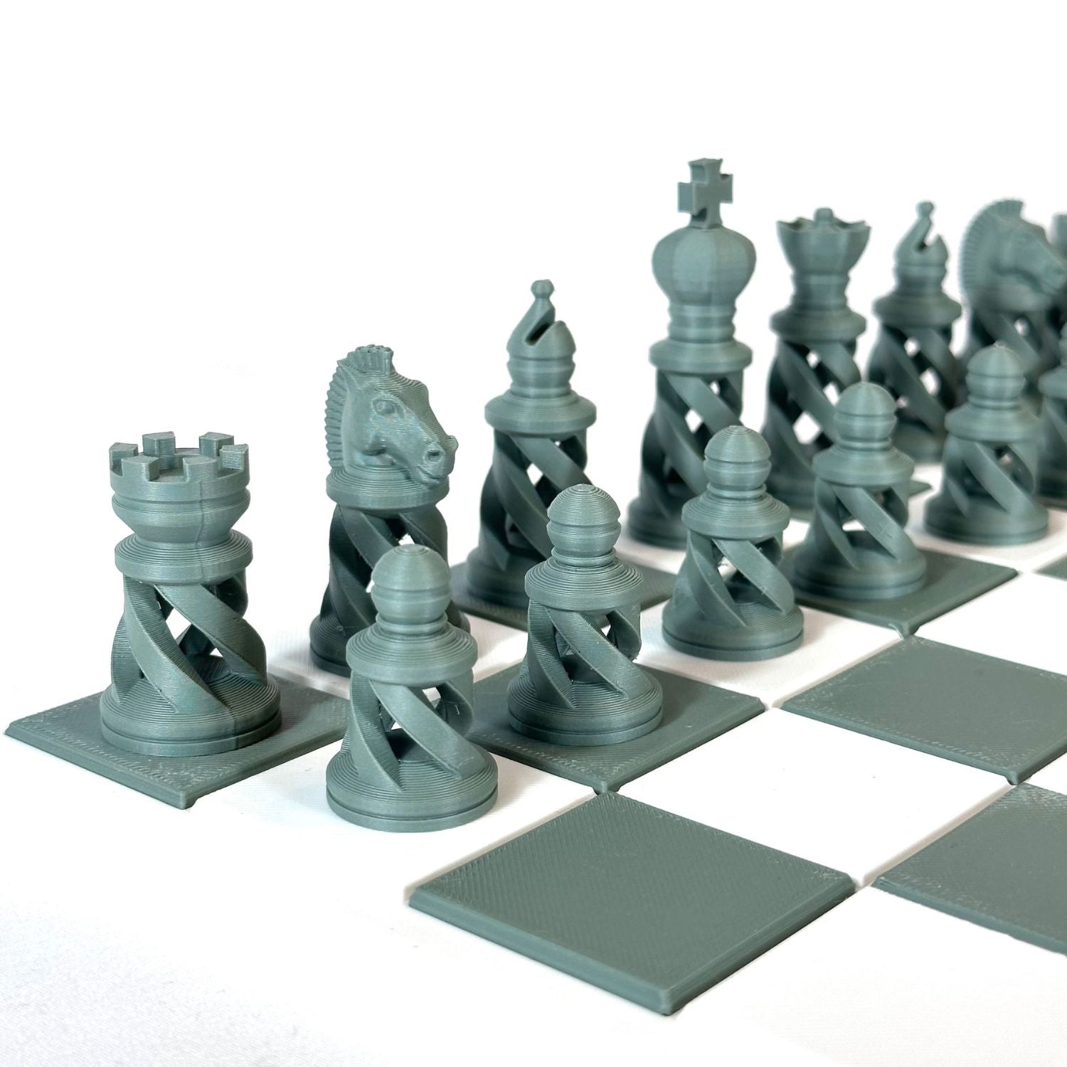 Pièces d’échecs modernes spiralées couleur vert doux sur échiquier blanc et vert, impression 3D de haute précision.